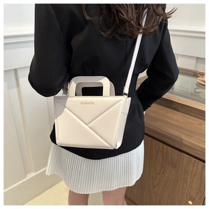 Detail of off-white leather handbag with geometric stitching and gold Fashion text