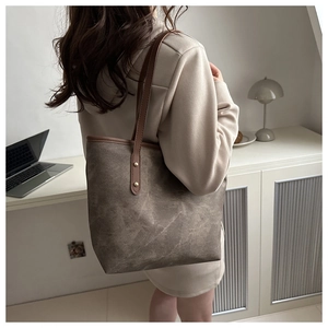 Macro shot of large brown textured faux leather tote bag with elegant gold rivet details