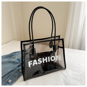 Detail view of transparent PVC tote bag with Fashion text and black leather handle