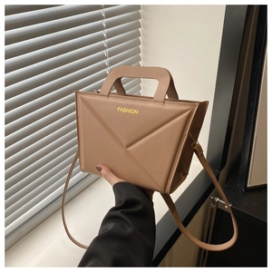 Detail of camel geometric folded handbag with yellow fashion text and handle