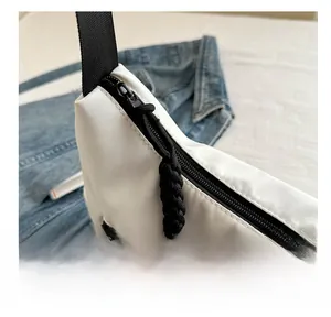 Gros plan détaillé de la fermeture éclair noire et de la sangle du sac fourre-tout blanc