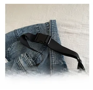 Détail de la bandoulière réglable en nylon noir avec boucle sur un sac cabas blanc