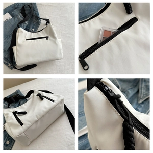 Vue détaillée du sac fourre-tout en nylon blanc avec poche zippée et rangement interne