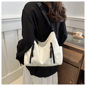 Détail d'un grand sac fourre-tout blanc en nylon avec zips noirs contrastés et poche latérale