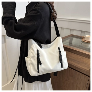 Détail d'un sac cabas blanc avec fermetures éclair noires et bandoulière robuste