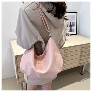 Détail du sac hobo en cuir PU rose montrant sa texture douce et sa longue bandoulière