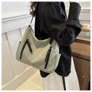 Détail du cabas en nylon vert clair avec tirettes tressées et poches latérales pratiques