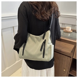 Vue détaillée du sac fourre-tout vert sauge avec bandoulière noire sur un modèle