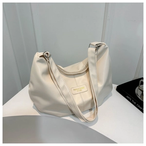 Détail du sac fourre-tout plissé blanc cassé avec texture synthétique et patch logo