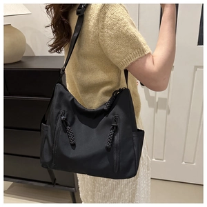 Détail du sac hobo en nylon noir avec grande capacité et tirettes de fermeture éclair en corde