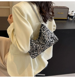 Détail d'un sac à bandoulière à paillettes argentées avec chaîne en métal chic