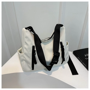 Détail du sac fourre-tout en nylon blanc avec large bandoulière noire et boucle en plastique