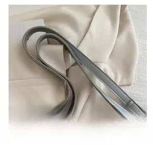 Detail of silver gray faux leather handle with double stitching and metal ring