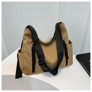 Détail du sac fourre-tout en nylon kaki avec poches latérales et tirettes tressées