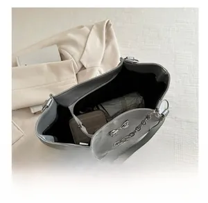 Detail view showing large capacity interior of silver shoulder bag with umbrella and wallet