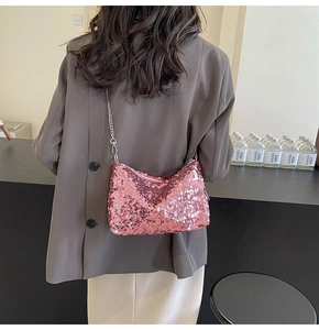 Gros plan du sac à bandoulière rose à paillettes avec chaîne argentée et zip