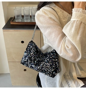 Gros plan des paillettes bleues scintillantes et de la chaîne sur un sac à main noir