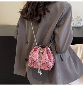 Dettaglio borsa a secchiello con paillettes rosa, catena argento e ciondoli in perla
