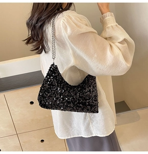 Détail de paillettes noires scintillantes et de la bandoulière chaîne argentée du sac