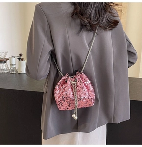 Détail du sac seau rose à paillettes avec bandoulière chaîne argentée et perles