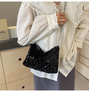 Détail du sac à paillettes noires avec bandoulière chaîne portée par un mannequin