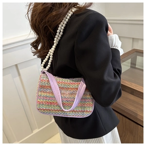 Détail du sac croissant tissé avec bordure en cuir violet et élégante bandoulière perle