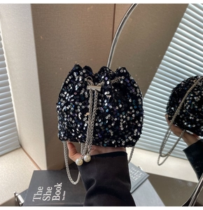 Dettaglio della borsa a secchiello nera con paillettes e coulisse a catena argento