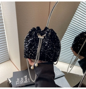 Dettaglio della borsa a secchiello con paillettes nere, catena argento e decori di perle