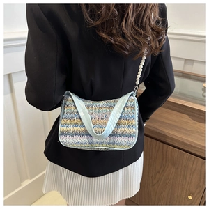 Détail du sac bandoulière tricoté à rayures avec broderie papillon et bandoulière perle