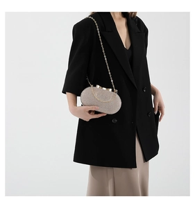 Detail of silver sequin evening clutch bag with gold chain strap and metal clasp