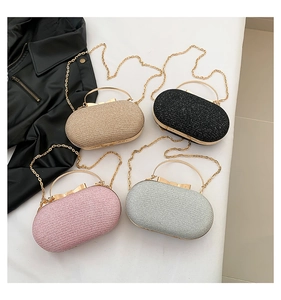 Detail view of oval hard shell evening bags with metal bow clasps and chain straps
