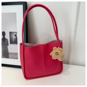 Dettaglio della grande borsa tote rosa in pelle PU con ciondolo a orsetto marrone