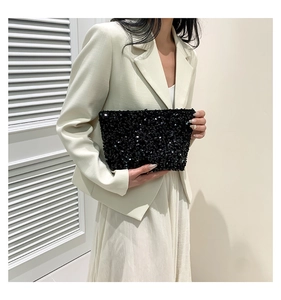 Fashionable black sequin clutch bag paired with a stylish beige blazer and dress