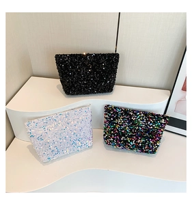 Detailed view of sequin clutch bags in black, iridescent white and multicolored finish