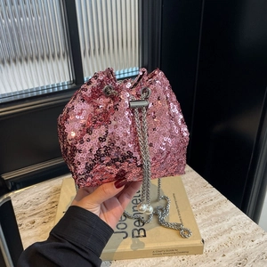 Sac seau rose à paillettes avec chaîne argentée et perles tenu à la main