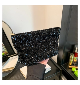 Close-up of black sequined evening clutch bag with elegant gold zipper detail