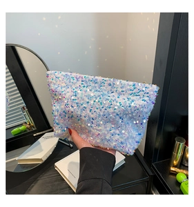 Close-up of blue purple gradient sequin makeup bag with golden metal zipper closure
