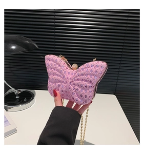Détail de la pochette papillon rose avec strass en cristal et chaîne dorée