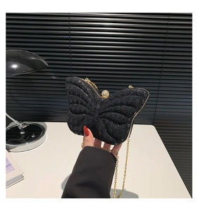 Détail de la pochette papillon scintillante avec chaîne dorée et fermoir diamanté
