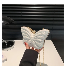 Gros plan de la pochette papillon blanche avec paillettes et bandoulière dorée