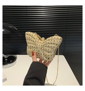 Détail d'une pochette de soirée en forme de papillon avec strass et fine chaîne dorée