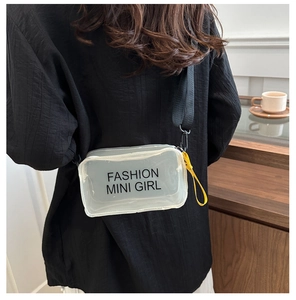 Détail du mini sac transparent en PVC avec imprimé FASHION MINI GIRL et ruban jaune