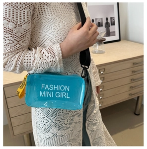 Détail du sac bandoulière bleu en PVC transparent avec sangle jaune et imprimé