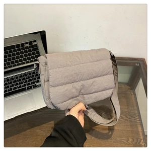 Close-up of a grey quilted nylon crossbody bag with wide strap for daily leisure use
