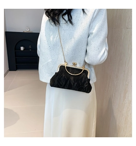 Détail du sac à main plissé noir avec fermoir doré vintage et poignée métallique