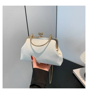 Gros plan d'une pochette de soirée en velours blanc avec cadre doré et fermoir boule