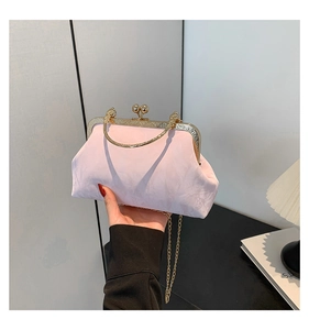 Détail du sac à main en tissu rose clair avec cadre doré et fermoir vintage