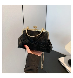 Gros plan d'un sac de soirée plissé noir avec cadre doré et fermoir à perles vintage