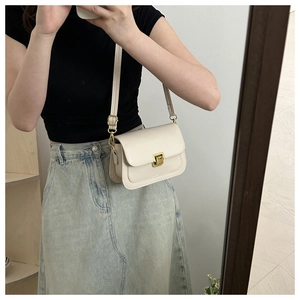 Mirror selfie showing the cream vintage flap bag worn as a shoulder bag on a person
