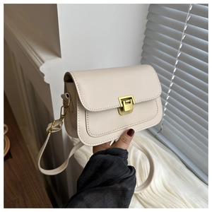 Detail view of cream-colored crossbody bag with vintage gold metal clasp and leather texture